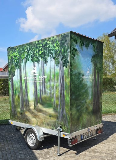 Ein Anhänger mit einer Waldlandschaft als grafischer Gestaltung.